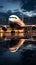A parked passenger aircraft near a jetway, its reflection glistening in a puddle