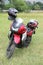 Parked red Kawasaki motorbike on green grass