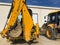 Parked yellow backhoe loader. Earthmoving, excavating, digging machinery at construction site