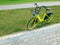 Parked yellow rent-a-bike near sidewalk