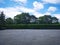 Parking lot sprinkled with gravel on tree bush nature background