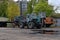 Parking of old Soviet diesel bulldozers and tractors on large wheels in the territory