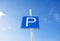 Parking sign on a pole on a blue sky background in sunny weather, curve sign