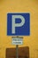 PARKING SPOT road sign in front of yellow wall