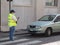 Parking warden wearing a facemask and issuing a parking rule violation on a mobile app in Lombardy