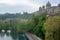 The parliament of Bern with lush trees and aare river on cloudy sky background