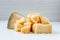 Parmesan pieces stacked in a pile on a white background