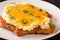 Parmo or Teesside Parmesan it consists of a breaded cutlet of chicken topped with a white bechamel sauce and cheddar cheese close-