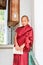 Paro, Bhutan - September 17, 2016: Young Bhutanese monk holding Buddhist scripture leaning to the monastery wall in Bhutan