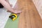 Parquet board and hands of the worker. Repair floor work with a laminate