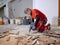 Parquet in wood glued to the slab, removed with an electric demolition hammer by a craftsman in workwear