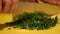 Parsley being mashed with knife