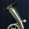 Part of baritone brass instrument against dark background