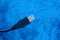 Part of a black computer cord on a blue background