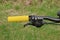 Part of a black metal bicycle handlebar with a handbrake and a yellow plastic handle