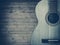 Part of a blue acoustic guitar on a gray wooden background.