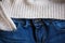 Part of blue jeans and woolen pullover close up. Selective focus