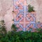 Part of blue and pink abstract mosaic between rocks and plants