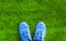 Part blue sports sneakers on the green grass textured