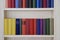 Part of bookcase with colorful covers in white wall