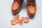 Part of brown autumn pair of boots on gray background with autumn oak leaves with copy space