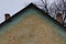 Part brown green brick loft against the sky and twigs