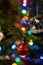 Part of christmas decorating house interior. Branch of xmas fir tree Illuminated garland. Xmas bauble toy closeup