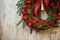 part of christmas spruce wreath decorated with red artificial ornaments