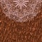 Part of a circular mandala ornament on a background of tree bark. Lace greeting card.