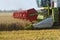 Part of a combine harvester working on a wheat field