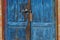 Part of the door of blue frayed wooden planks and padlock