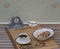 A part of an english tea set in front of a pale blue Wedgwood watch, Jasperware, on an old German daily newspaper Der Patriot