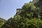 Part of a fortification on a cliff seen from a park below