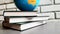 Part of the globe is spinning on a stack of books against a white brick wall, education concept, 4K video