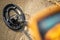 Part of the metal detector in the foreground blurred and coil device on the sand, metal search in the summer