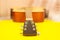 Part of the neck of an acoustic guitar and a string-tensioning bar. Close up. On yellow background. copy space