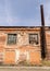 Part of an old red brick factory with an old rusty chimney.