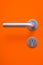 The part of orange door with metal handle