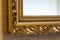 Part of the ornate, golden color carved mirror frame in ancient