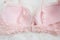 Part of pink bodice with lace on white fur. Inner side. Underwear, fashion concept. Close up