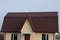 Part of a private large white brick house with windows under a brown tiled roof