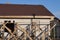 Part of a private unfinished house of white bricks with windows under a brown tiled roof