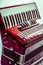 Part red musical instrument accordion, white background