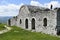 Part of the remaining castle in Berat. On the roof of the ruins is a girl in a plaid shirt and jeans. Berat, Albania