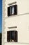 Part of residential building with windows of apartments shades and flower boxes, closeup / Building facade elements.