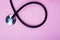 Part of stethoscope on pink background