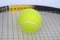 Part of tennis racquet with yellow ball clo