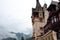Part view of Peles Castle on a cloudy day