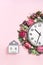 Part of wall clock in blooming flowers on candy pink background