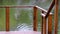 Part of wooden railings of empty bridge on a flowing river background. Tranquility at beautiful calm summer day.